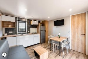 a kitchen and dining room with a table and chairs at Camping Les Violettes in La Faute-sur-Mer