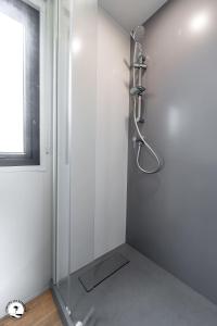 um chuveiro num quarto branco com um microfone em Camping Les Violettes em La Faute-sur-Mer