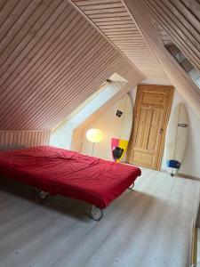 1 dormitorio con 1 cama roja y 2 tablas de surf en Vackert gathus i Gamla Limhamn nära Eurovision en Malmö