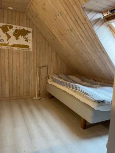 1 dormitorio con 1 cama en una habitación de madera en Vackert gathus i Gamla Limhamn nära Eurovision en Malmö