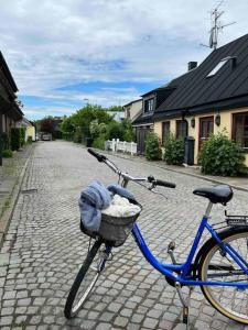 Una bicicleta azul con una cesta en una calle de ladrillo en Vackert gathus i Gamla Limhamn nära Eurovision en Malmö