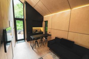 a living room with a black table and a couch at LagomHome Luxus Pihenőház ***** Noszvaj in Noszvaj