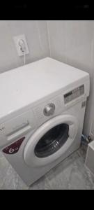 uma máquina de lavar roupa branca num canto de um quarto em Аренда 2-х комнатной квартиры в г.Астана, Казахстан em Taldykolʼ