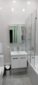 uma casa de banho com um lavatório, um chuveiro e um WC. em Аренда 2-х комнатной квартиры в г.Астана, Казахстан em Taldykolʼ