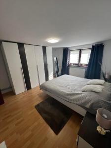 een slaapkamer met een groot bed en een houten vloer bij Apartament Koninki in Poręba Wielka