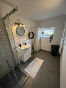 een badkamer met een douche, een wastafel en een spiegel bij Apartament Koninki in Poręba Wielka