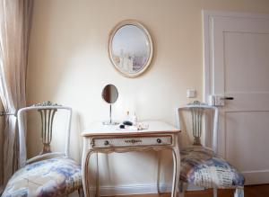 a dressing table with two chairs and a mirror at REFUGIUM Theresienstraße 19 - Chambre Morisot in Rhodt unter Rietburg