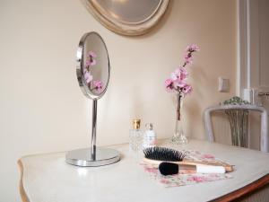 a table with a mirror and a makeup brush and a makeup brush holder at REFUGIUM Theresienstraße 19 - Chambre Morisot in Rhodt unter Rietburg