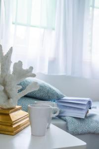 a coffee cup sitting on a table with books at Casa de Buenas in Sarbinowo