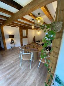 - un salon avec une table, des chaises et une plante dans l'établissement L'ancien Hôtel du vieux Cèdre, à Arreau