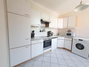 a kitchen with white cabinets and a washer and dryer at Ferienwohnung Stadtvilla - charmante Gemütlichkeit in Bad Oldesloe