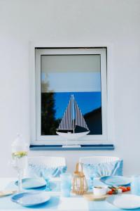 a table with a sail boat in a window at Casa de Buenas in Sarbinowo