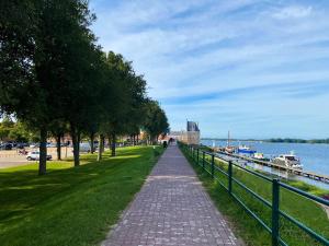 Un camino de ladrillos junto a un río con una valla. en Vakantiehuis Gapinge GA03 met omheind terras, en Gapinge