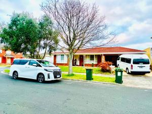 two white cars parked in front of a house at Spacious 6 Bedroom Holiday Home 15 Min Away From Melbourne Airport in Sydenham