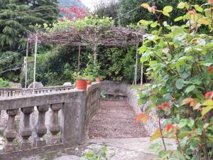 a garden with a stone bridge with a pergola at VILLA MARIA in Torno