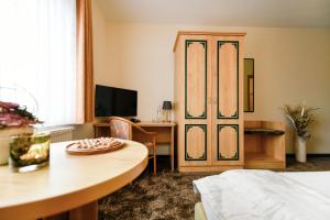 Zimmer mit einem Bett und einem Schreibtisch mit einem Tisch und einer Tür in der Unterkunft Christinenhof & Spa - Wellnesshotel am Rande des Spreewalds in Tauer