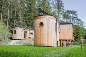 a large wooden house in the middle of a field at WOHNWAGON Tiny Houses I in Gutenstein
