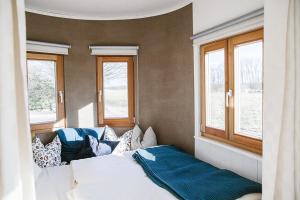 a bedroom with a bed and two windows at WOHNWAGON Tiny Houses I in Gutenstein