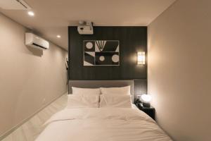 sypialnia z białym łóżkiem i czarną ścianą w obiekcie AANK Ryokan Hotel Paju w mieście Paju