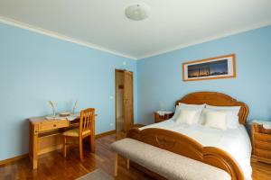 sypialnia z niebieskimi ścianami, łóżkiem i biurkiem w obiekcie Refúgio de Alburitel w mieście Alburitel