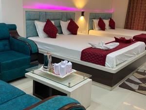 a hotel room with two beds and a couch at Dayal International - New Digha in Digha