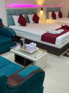 a hotel room with two beds and a couch at Dayal International - New Digha in Digha