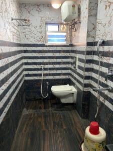 a bathroom with a toilet and a sink and a window at Dayal International - New Digha in Digha