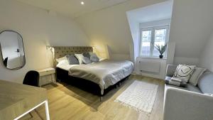 1 dormitorio con cama, espejo y silla en Attic Living Hostel, en Borås
