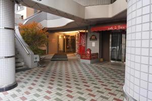 a building with a tiled floor in front of a store at シティラデファンス - 市営東西線 琴似駅徒歩2分 - リニューアル済の少人数旅行に最適な快適ステイ in Sapporo