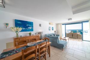 a living room with a table and a blue couch at Brisa Marina in Puerto Calero