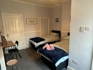 Zimmer mit 2 Betten, einem Schreibtisch und einem Tisch in der Unterkunft Apartment 3 Petteril House in Carlisle