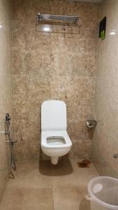 La salle de bains est pourvue de toilettes blanches et d'un lavabo. dans l'établissement Golden View Dormitory, à Mumbai