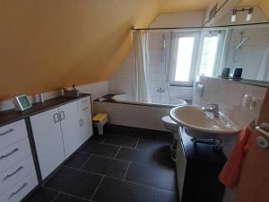 a bathroom with a sink and a bath tub at B&B Koeln Zuendorf in Cologne