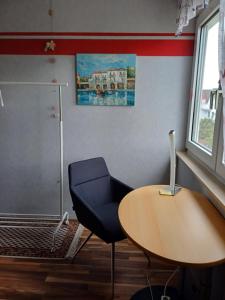 a office with a desk and a chair and a table at B&B Koeln Zuendorf in Cologne