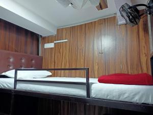 una camera con un letto e una parete in legno di Golden View Dormitory a Mumbai