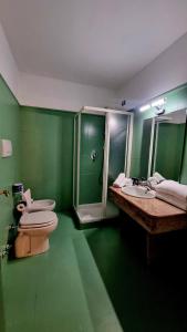 a green bathroom with two sinks and a shower at Botanique Hotel Vergani in Fara Gera dʼAdda