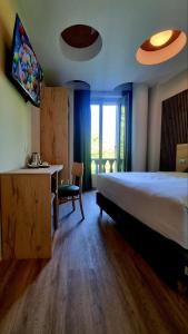 a bedroom with a bed and a desk and a window at Botanique Hotel Vergani in Fara Gera dʼAdda