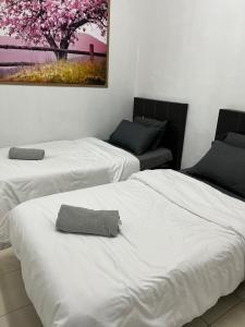 a room with two beds and a painting on the wall at Az-zahra Home Stay Kulim Hi-Tech in Kulim