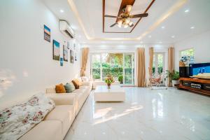 a living room with a couch and a tv at Villa FLC Sầm Sơn SH20 in Sầm Sơn