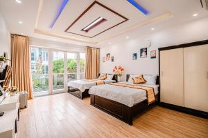 a bedroom with two beds and a large window at Villa FLC Sầm Sơn SH20 in Sầm Sơn