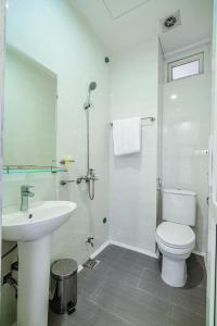 La salle de bains blanche est pourvue d'un lavabo et de toilettes. dans l'établissement Villa FLC Sầm Sơn SH20, à Sầm Sơn