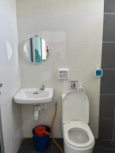 a bathroom with a toilet and a sink and a mirror at Az-zahra Home Stay Kulim Hi-Tech in Kulim