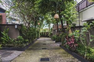 a walkway in a garden with trees and plants at Canggu Circle Villa by Ini Vie Hospitality in Canggu