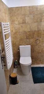 bagno con servizi igienici bianchi e parete piastrellata di Location Gîte en Provence a Beaucaire