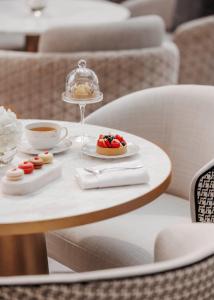 una mesa con un plato de comida y una taza de café en Jumeirah Emirates Towers Dubai, en Dubái