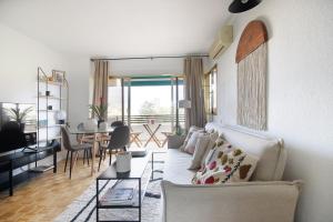 sala de estar con sofá blanco y mesa en Apartamento tres habitaciones en Nou Barris by Alterhome, en Barcelona