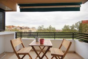 2 sillas y una mesa en el balcón en Apartamento tres habitaciones en Nou Barris by Alterhome, en Barcelona