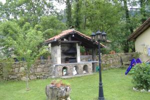 una chimenea de piedra en un patio con luz de la calle en casa rural CABORZAL, en Renedo