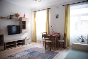 ein Wohnzimmer mit einem Tisch und einem TV in der Unterkunft Seek and Hide - Ilse's Hideaway in Braşov