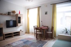 un soggiorno con un tavolo e una tv di Seek and Hide - Ilse's Hideaway a Braşov